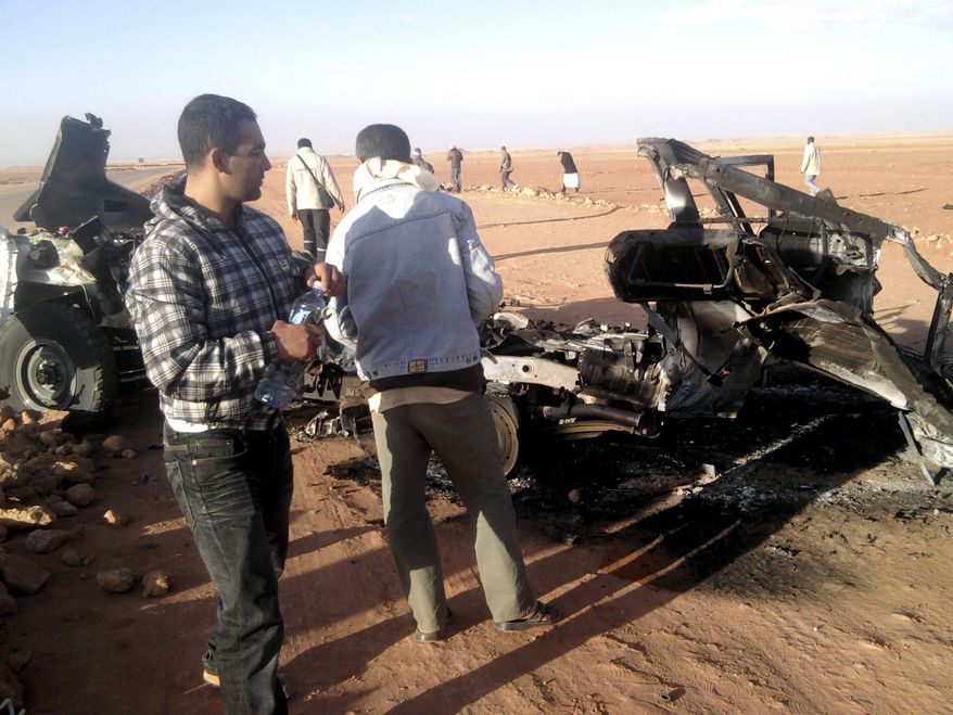 Men look at the wreckage of a vehicle near the natural-gas plant in Ain Amenas, Algeria, in this undated photo. Algerian bomb squads on Sunday, Jan. 20, 2013, scoured the plant, where Islamist militants took dozens of foreign workers hostage, and found "numerous" new bodies as they searched for explosive traps left behind by the attackers, a security official said, a day after a bloody raid ended the four-day siege of the remote desert refinery. (AP Photo/Echorouk Elyaoumi)