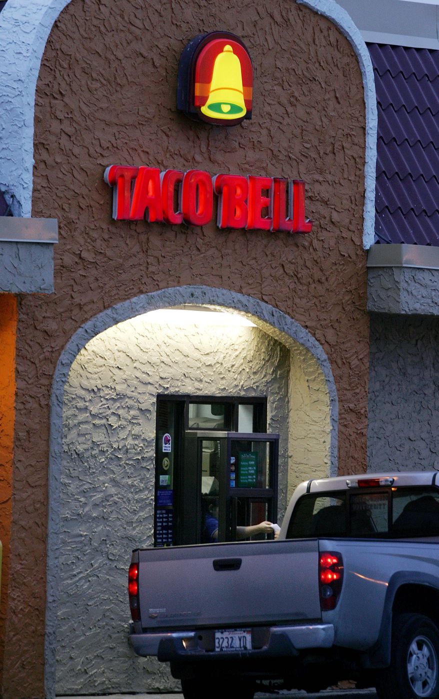 **FILE** A worker hands an order from the drive-thru window at a Taco Bell restaurant in South Plainfield, N.J., on Dec. 12, 2006. (Associated Press)