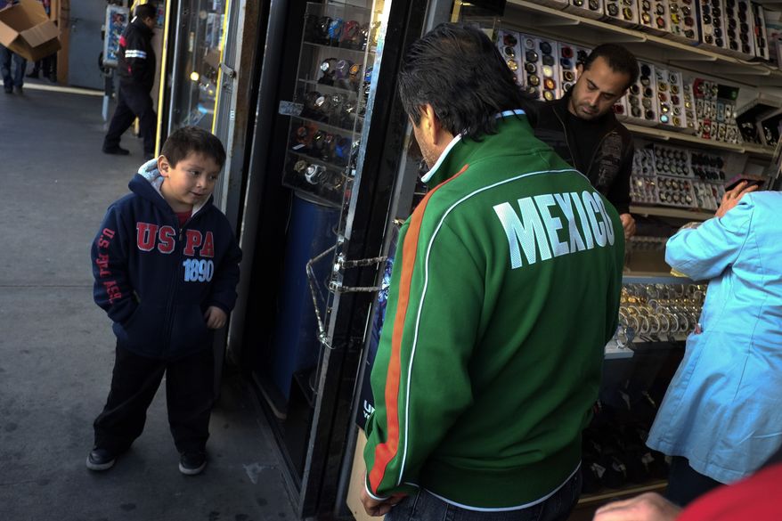 Mexican immigrant Roberto Garcia (center) and son Alan (left) look at wristwatches while shopping in Los Angeles on Jan. 28, 2013. (Associated Press)