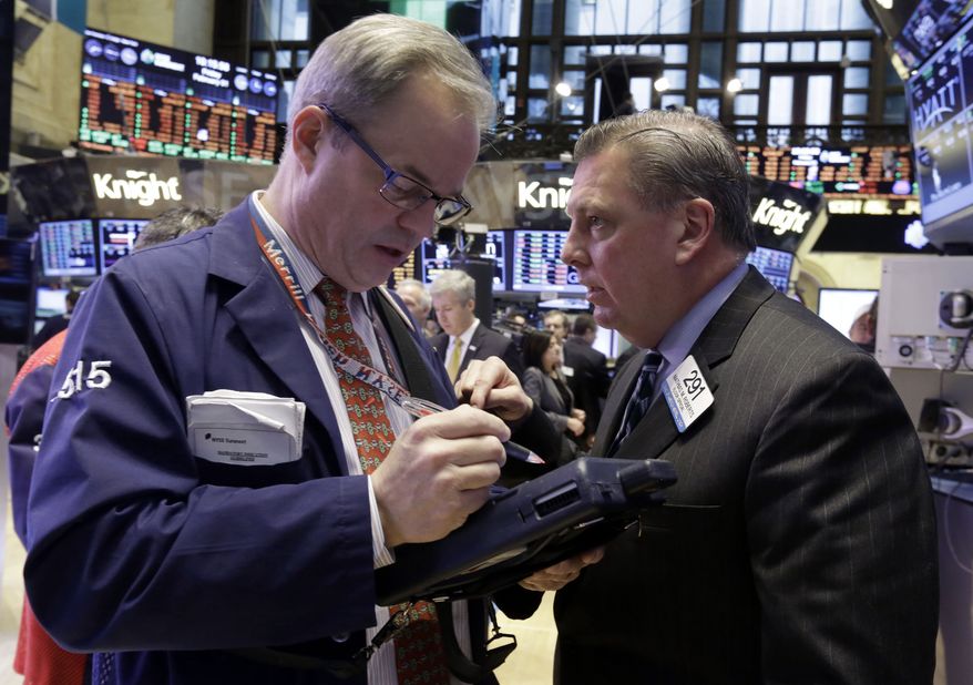 Traders David O'Day (left) and Mathias Roberts work on the floor of the New York Stock Exchange on Feb. 1, 2013. (Associated Press)