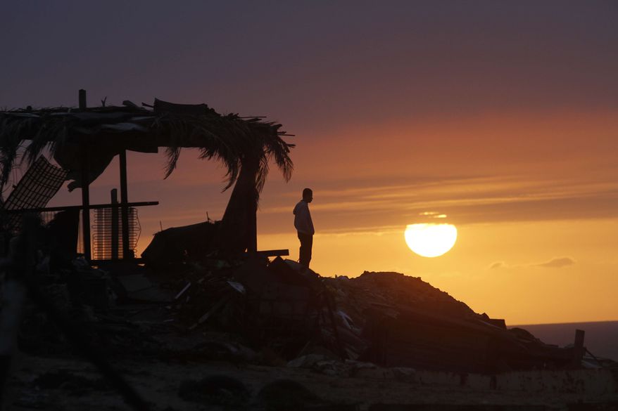 ** FILE** A Palestinian watches a sunset in Gaza City, Sunday, Feb. 10, 2013. (AP Photo/Hatem Moussa)