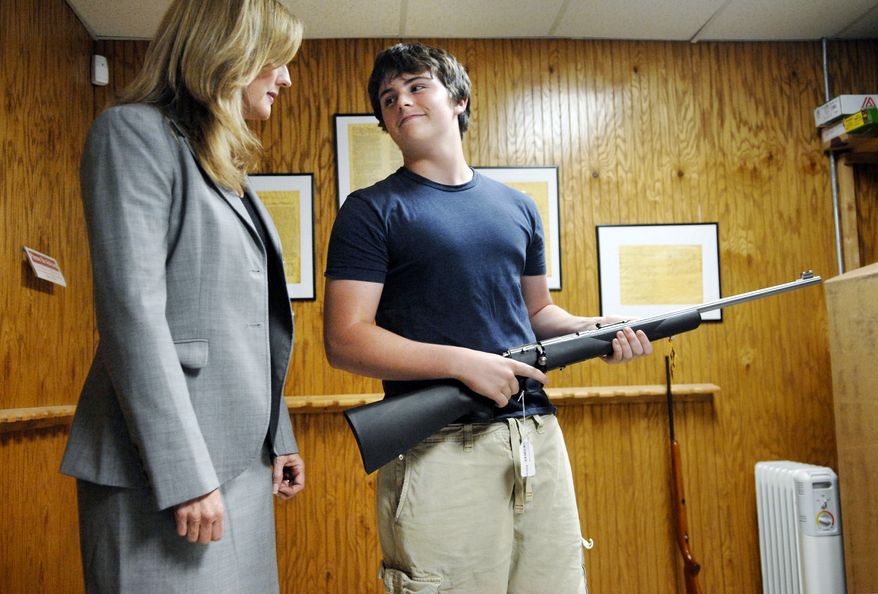 ** FILE ** Michael Steelman (right), 13, smiles at his mother, Missouri state Treasurer Sarah Steelman, after picking out a rifle while shopping at Ammo Alley in Hartsburg, Mo., on May 28, 2008. Mrs. Steelman held a press conference to discuss her support of the Second Amendment to the U.S. Constitution before buying her son the rifle for his birthday. Ammo Alley owner J. Doug Alley helped the two pick out the Marlin 917S 17HMR model. (Nick King Photo/Columbia Daily Tribune/Associated Press)