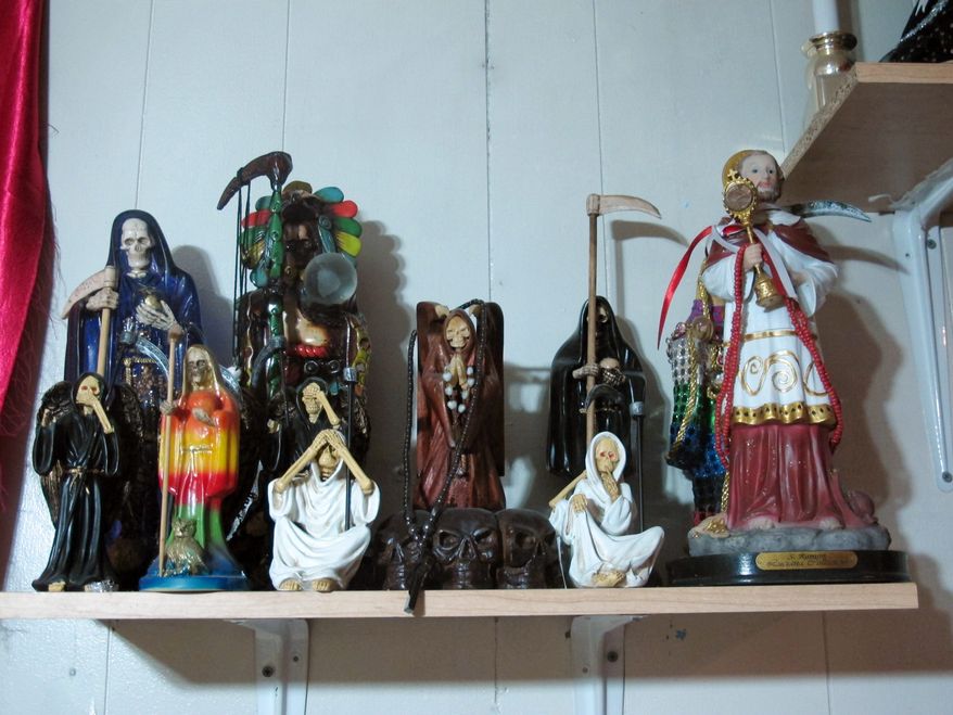 ** FILE ** In this Feb. 12, 2013, photo, statues of La Sante Muerte from an altar run by Arely Vazquez Gonzalez, a Mexican immigrant and transgender woman, is shown inside a Queens, NY apartment. La Santa Muerte, an underworld saint most recently associated with the violent drug trade in Mexico, now is spreading throughout the U.S. among a new group of followers ranging from immigrant small business owners to artists and gay activists. (AP Photo/Russell Contreras)