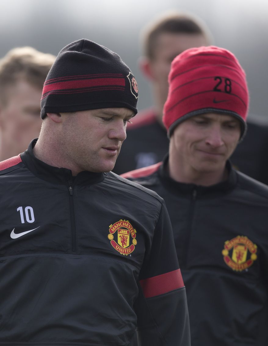 Manchester United's Wayne Rooney, left, trains with teammates at Carrington training ground in Manchester, Monday, March 4, 2013. Manchester United will play Real Madrid in a Champions League round of 16 soccer match on Tuesday. (AP Photo/Jon Super)