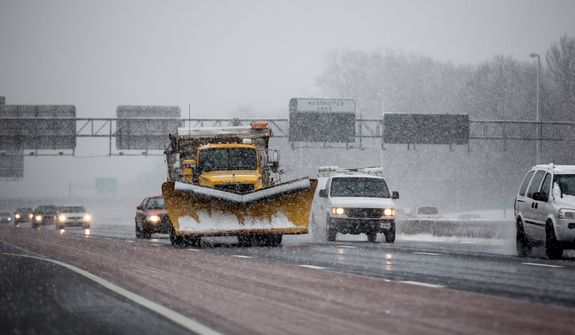 A snowplow dispenses salt as it rolls down I-66, near Route 50 in Fairfax, Va., on March 6, 2013. (Andrew S. Geraci/The Washington Times)