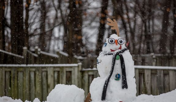 A freshly made snowman is adorned with a scarf and accessories in a neighborhood in Fairfax, Va., on March 6, 2013. (Andrew S. Geraci/The Washington Times)
