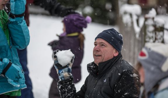 Patrick Sweeney prepares to throw a snowball at one of his children in Fairfax, Va., on March 6, 2013. (Andrew S. Geraci/The Washington Times)