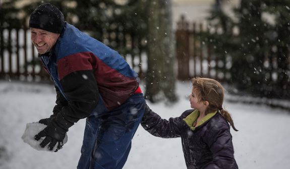 Mike Powers grimaces as his daughter drops snow down his pants during a snowball fight in Fairfax, Va., on March 6, 2013. (Andrew S. Geraci/The Washington Times)