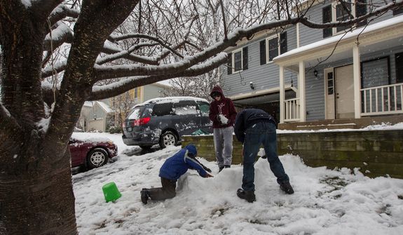 Mason Moy (center), 14, Sam Gustason (right), 13, and Calvin Crist, 13, build a snow fort in a front yard during a snow day in Fairfax, Va., on March 6, 2013. (Andrew S. Geraci/The Washington Times)