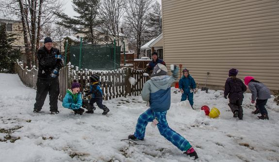 The Sweeney and Powers families engage in a snowball fight in Fairfax, Va., on March 6, 2013. (Andrew S. Geraci/The Washington Times)