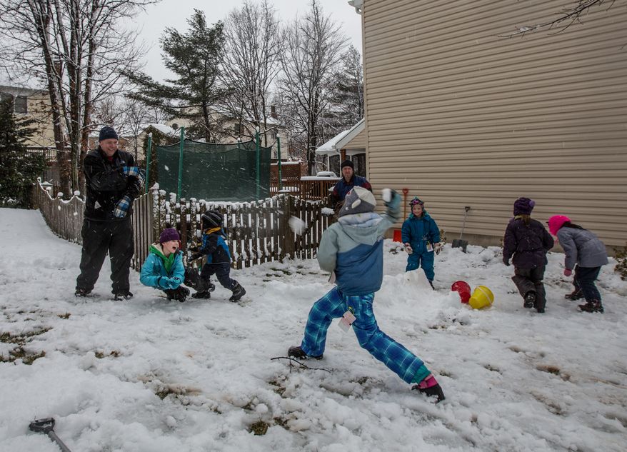 The Sweeney and Powers families engage in a snowball fight in Fairfax, Va., on March 6, 2013. (Andrew S. Geraci/The Washington Times)