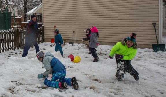 The Sweeney and Powers families engage in a snowball fight in Fairfax, Va., on March 6, 2013. (Andrew S. Geraci/The Washington Times)