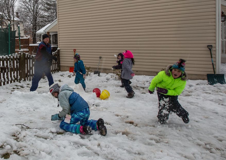 The Sweeney and Powers families engage in a snowball fight in Fairfax, Va., on March 6, 2013. (Andrew S. Geraci/The Washington Times)