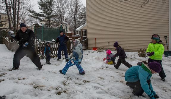 The Sweeney and Powers families engage in a snowball fight in Fairfax, Va., on March 6, 2013. (Andrew S. Geraci/The Washington Times)