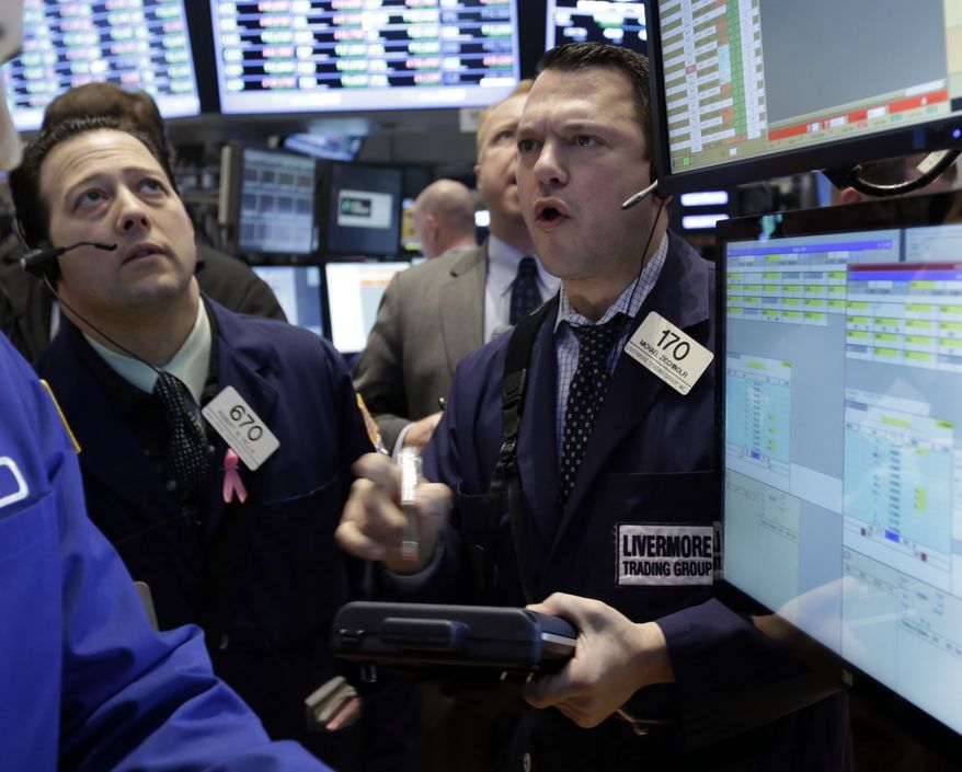 Tader Michael Zicchinolfi (right) works on the floor of the New York Stock Exchange on March 8, 2013. (Associated Press)
