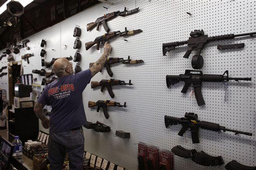 ** FILE ** Gun dealer Mel Bernstein takes down an AK-47 assault rifle from a sales rack at his own Dragonman's shooting range and gun store, east of Colorado Springs, Colo., Feb. 15. (AP Photo/Brennan Linsley)