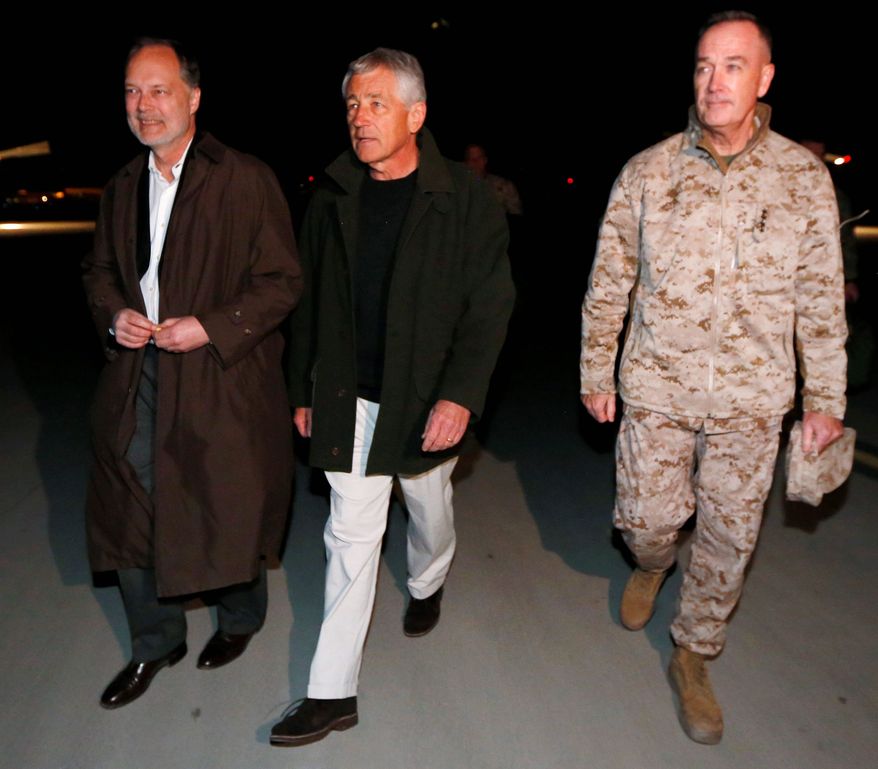 THE LATEST: Gen. Joseph F. Dunford, Jr., (right) takes the hand and the command of Gen. John Allen during a February ceremony in Kabul, Afghanistan. Gen. Dunford became the fifth commander of the war in the past five years. (Associated Press)
