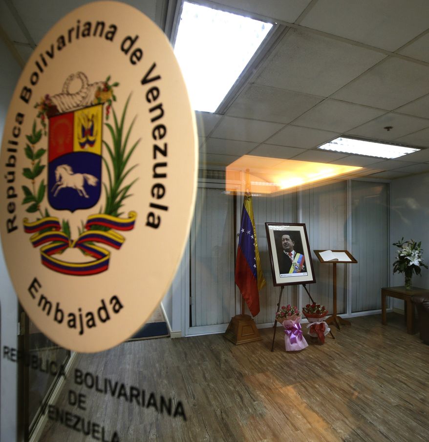 **FILE** A room with a portrait of the late Venezuelan President Hugo Chavez is prepared for supporters and members of the diplomatic corps to pay tribute and sign the book of condolences at the Venezuelan Embassy in the financial district of Makati city east of Manila, Philippines, on March 7, 2013. Chavez died Wednesday after a long bout with cancer. He was 58. (Associated Press)