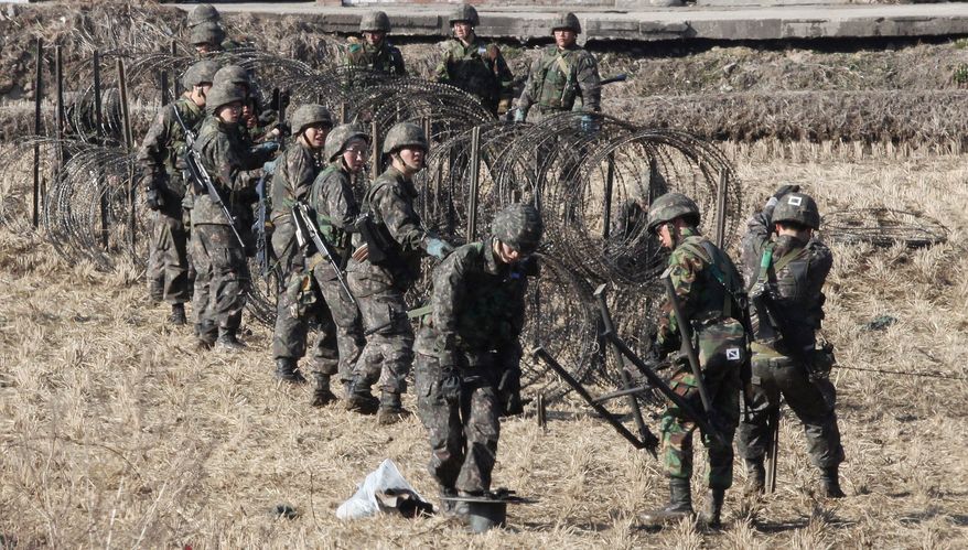 South Korean Army soldiers set up barbed wire fence during an exercise against possible attacks by North Korea near the border village of Panmunjom in Paju, South Korea, Monday, March 11, 2013. (AP Photo/Ahn Young-joon)