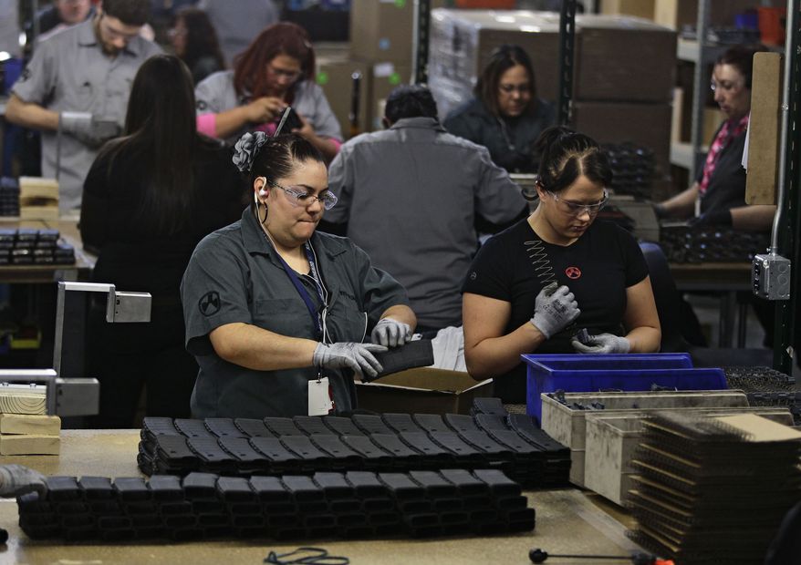 **FILE** Workers assemble 30-round capacity ammunition magazines for high-velocity rifles inside the Magpul Industries plant in Erie, Colo., on Feb. 28, 2013. (Associated Press)