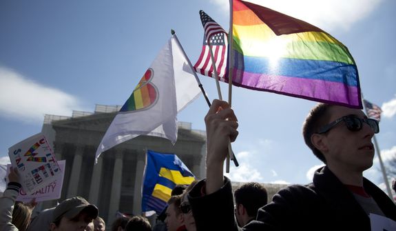 Kevin Coyne of Washington holds flags in front of the Supreme Court in Washington on March 27, 2013. The U.S. Supreme Court, in the second day of gay marriage cases, turned to a constitutional challenge to the federal law that prevents legally married gay Americans from collecting federal benefits generally available to straight married couples. (Associated Press)
