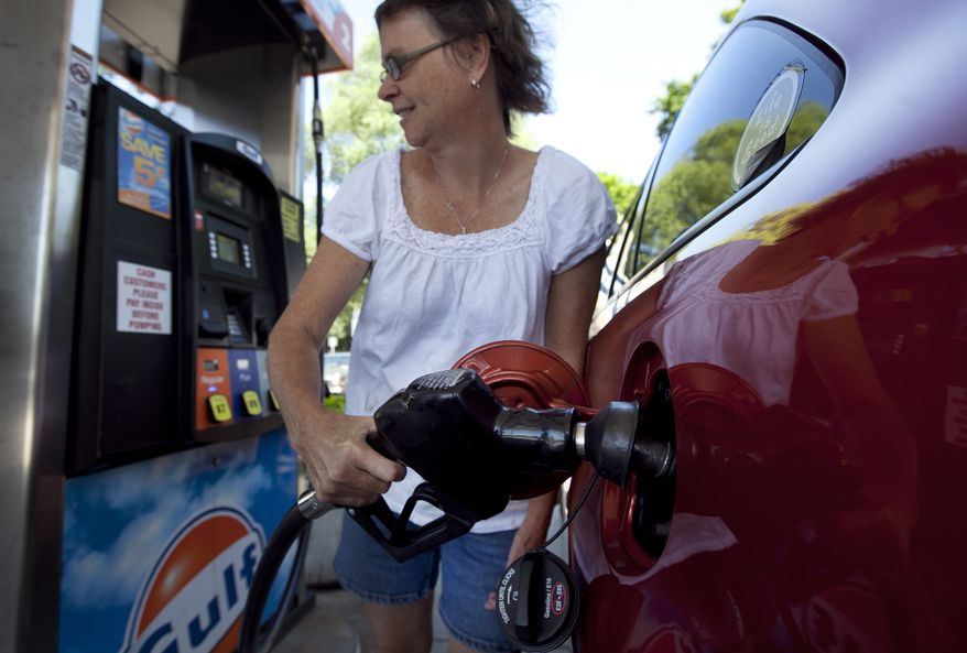 **FILE** Suzanne Meredith, of Walpole, Mass., gases up her car at a Gulf station in Brookline, Mass., on July 10, 2012. (Associated Press)