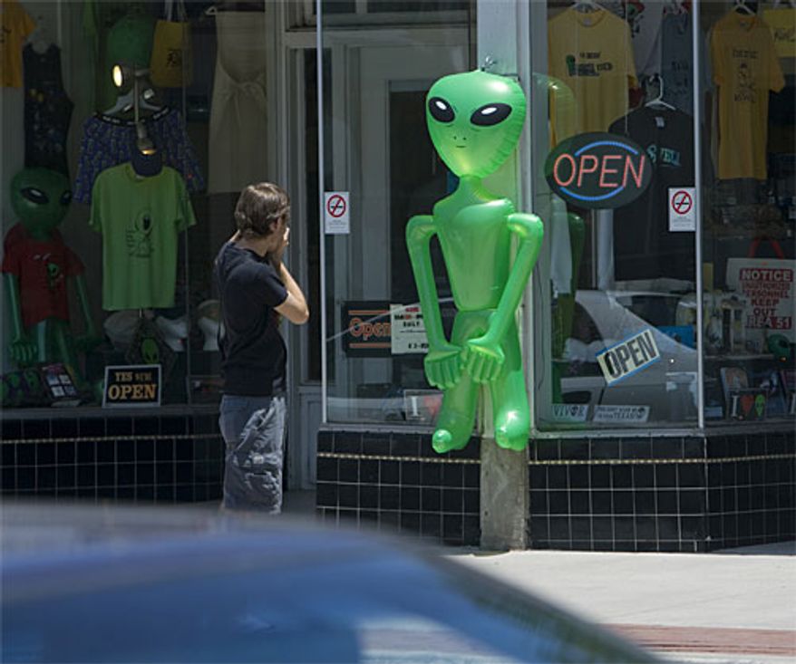 ** FILE ** A tourist photographs an alien outside a T-shirt and souvenir shop in Roswell, N.M., in 2007. (Associated Press)