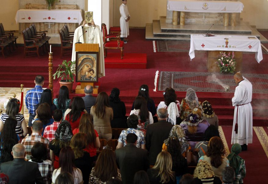 Iraqi Christians pray during Easter Mass at Mar Youssif Chaldean Church in Baghdad on Sunday, March 31, 2013. The Chaldean Church is an Eastern Rite church affiliated with the Roman Catholic Church. (AP Photo/Karim Kadim)