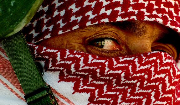 Iraqi policemen wrap their faces with scarves to conceal their identity before heading out on patrols from Al Huriya Police Station in Ramadi, Iraq, July 27, 2006. (U.S. Air Force photo by Tech. Sgt. Jeremy T. Lock)