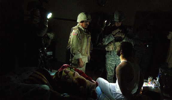 An Iraqi Army interpreter and a Soldier from Bravo Company 1/17th Infantry 172nd Stryker BDE Ft. Wainwright, AK question a suspect during an early morning cordon search of a house May 26, 2006 in the North West neighborhood of Al Nijar, Mosul, Iraq. Nine Iraqi's were detained in the searches, all suspected of terrorist activity as IED facilitators and enablers. (U.S. Air Force photo by TSgt Jeremy T. Lock)