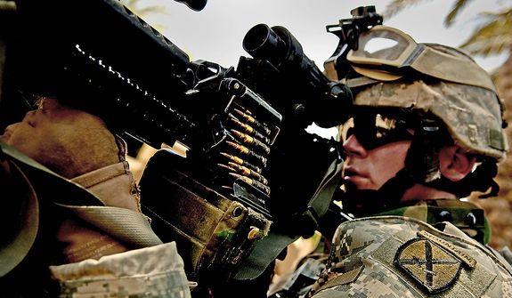 PFC Chris Smith from Alpha Company, 1st BN, 87th Infantry, 10th Mountain Division, Fort Drum NY secures the perimeter May 21, 2006 while his patrol leader talks to local Iraqi's as they patrol through the streets of Ameriah, a suburb of Baghdad Iraq. (U.S. Air Force photo by TSgt Jeremy T. Lock)