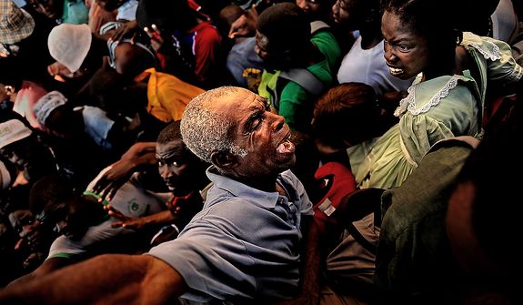 An older man is squished while he tries to get out of the way of a huge number of Haitians making their way to the relief supplies (food and water) the U.S. Army Soldiers with Charlie Company, 2nd Battalion, 325th Airborne Infantry Regiment, 2nd Brigade Combat Team, 82nd Airborne Division, Fort Bragg, NC,were handing out on January 20, 2010 at the stadium in Port au Prince, Haiti, for Operation Unified Response. As more and more Haitians heard of the distribution being handed out by the soldiers, the distribution line turned into a huge gathering of people being pushed from the back. The soldiers stood their ground and handed out the majority of the relief for as long as they could before they were hugely out numbered and over run. (U.S. Air Force photo by Tech. Sgt. Jeremy T. Lock)