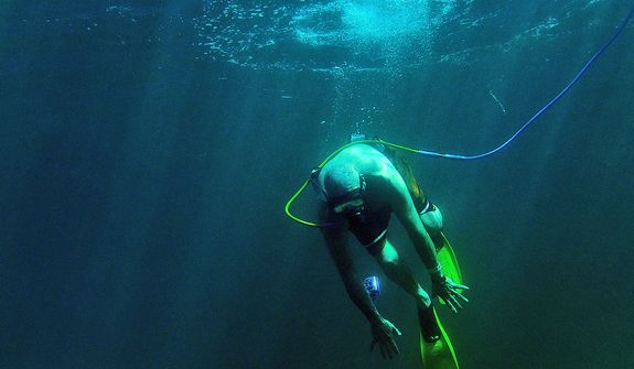 Paul Kuntne tries to dive down as he Snuba's for the first time off the coast of Roatan, Honduras on December 25, 2012. Snuba is an underwater breathing system. The air, however, instead of coming from tanks strapped to the diver's back, comes through a long hose from tanks on pontoon rafts on the surface. Paul retired from the Coast Guard where he served as part of the Presidential Honor Guard. (U.S. Air Force photo by Tech. Sgt. Jeremy T. Lock)