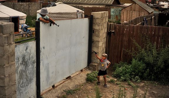 Two young boys run around and play with toy guns in the Ger District in Ulaanbaatar, Mongolia on July 28, 2012. Ger districts usually occupy poor quality land on the outskirts of town. (U.S. Air Force photo by Tech. Sgt. Jeremy T. Lock)