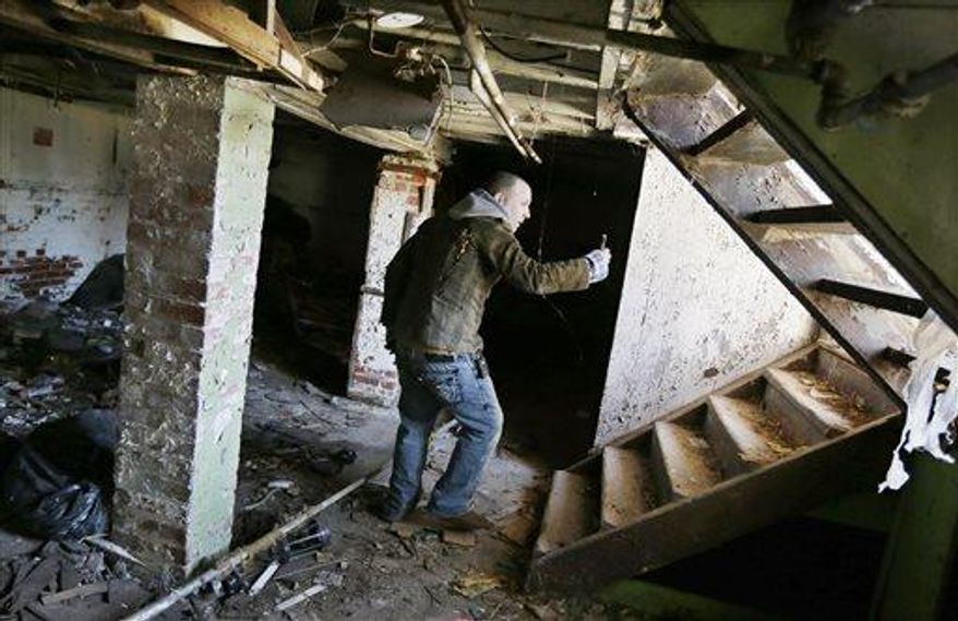 Tony Majka, who is also known as Tony Detroit on Instagram, uses his iPhone to photograph inside an abandoned home in Detroit, April 3, 2013. Majka has been chronicling Detroit's blight epidemic in a unique and popular way. Under the name "Tony Detroit," he's been taking photos of the city's many abandoned structures with an iPhone and posting them on Instagram. The simple shots of Detroit's desolation has earned him better than 300,000 followers. (AP Photo/Carlos Osorio)