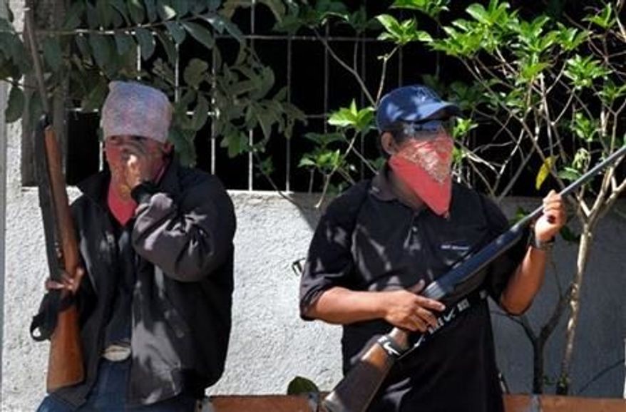 ** FILE ** Men cover their faces and carry small arms in the Mexican state of Guerrero, Jan. 11, 2013. (AP Photo/Bernandino Hernandez)