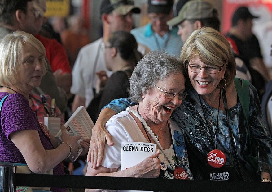 Eby Owen, center, of Dunedin, Fla., and Debbie Brinson, right, of San Antonio share a hug as they wait in line for the Glenn Beck book signing event during the NRA convention at the George R. Brown Convention Center Saturday, May 4, 2013, in Houston. National Rifle Association leaders told members Saturday that the fight against gun control legislation is far from over, with battles yet to come in Congress and next year's midterm elections, but they vowed that none in the organization will ever have to surrender their weapons. (AP Photo/Houston Chronicle, Melissa Phillip)