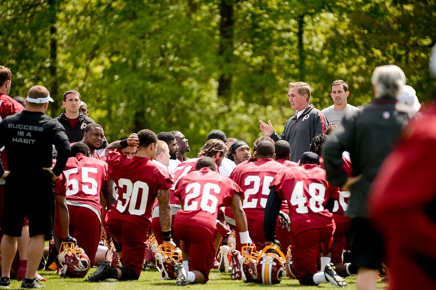Washington Redskins head coach Mike Shanahan talks to players at the team's rookie minicamp at Redskins Park in Ashburn, Va., on Sunday, May 5, 2013. Also pictured is offensive coach Kyle Shanahan (right). (Andrew Harnik/The Washington Times)