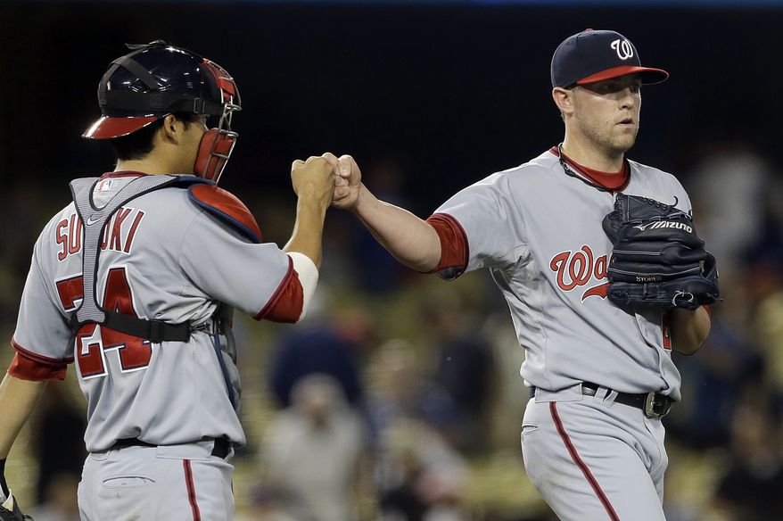 Washington Nationals closer Drew Storen and catcher Kurt Suzuki celebrate their win over the Los Angeles Dodgers in a baseball game in Los Angeles Monday, May 13, 2013. The Nationals won, 6-2. (AP Photo/Reed Saxon)