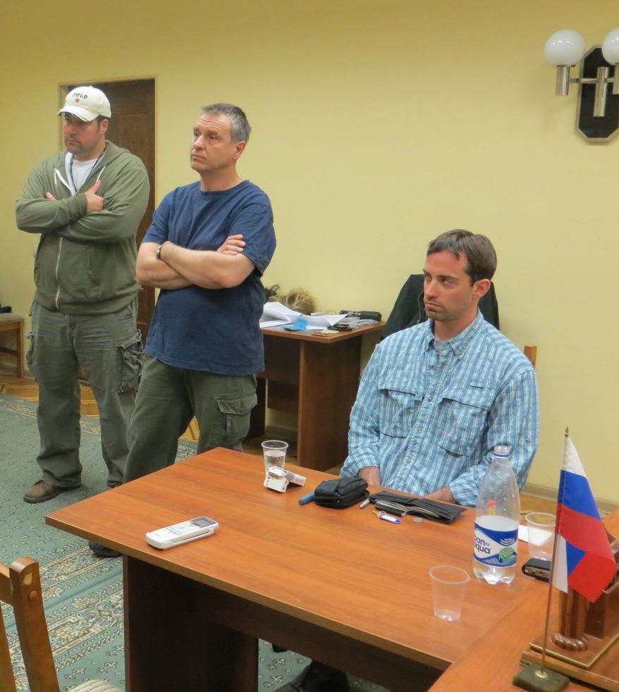 In this handout photo provided by the FSB, acronym for Russian Federal Security Service, a man claimed by FSB to be Ryan Fogle, right, a third secretary at the U.S. Embassy in Moscow, with Embassy officials at left, sits in the the FSB offices in Moscow, early Tuesday, May 14, 2013. Russia's security services say they have caught a U.S. diplomat who they claim is a CIA agent in a red-handed attempt to recruit a Russian agent. (AP Photo/FSB Public Relations Center)