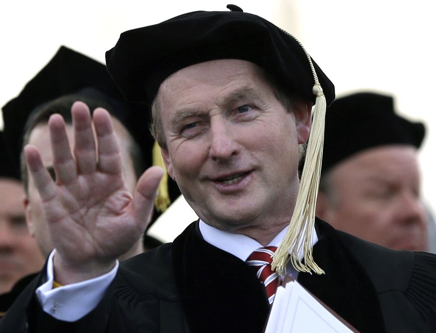 Irish Prime Minister Enda Kenny waves to students from the dais at Boston College, from which he received an honorary degree during commencement ceremonies at Alumni Stadium in Chestnut Hill, Mass., on Monday, May 20, 2013. Cardinal Sean O'Malley, who as archbishop of Boston traditionally would have given the benediction at the ceremony, skipped the event because of the involvement of Mr. Kenny, who supports a bill in his country that would allow abortion. (AP Photo/Elise Amendola)