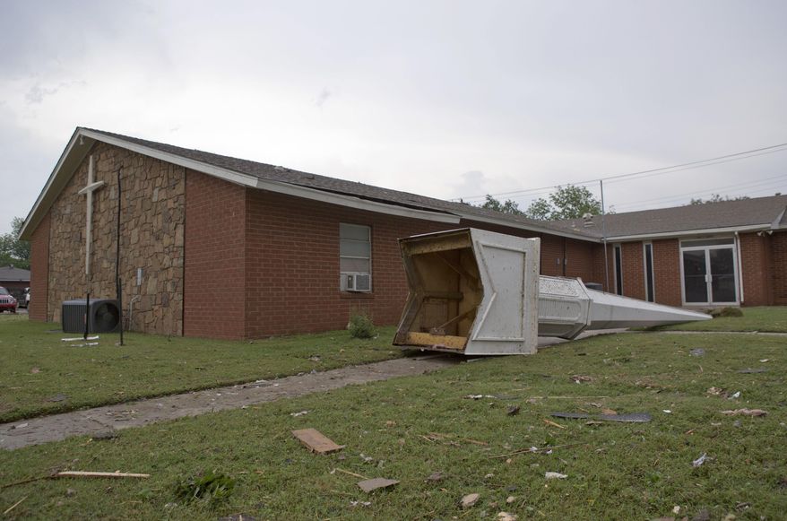 The steeple of a church at South Janeway Avenue and SW 4th Street lays across the lawn after a tornado moved through Moore, Okla., on Monday, May 20, 2013. (AP Photo/Alonzo Adams)