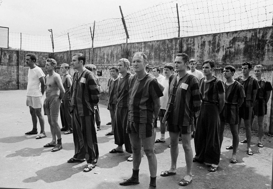 ** FILE ** In this March 29, 1973, file photo, unidentified U.S. prisoners of war stand in the courtyard of Hanoi's POW camp at Nga Tu So street waiting for an inspection of the camp by joint military and international control and supervision commissions. On Thursday, May 24, 2013, some 200 former POWs, almost all of them former pilots, will reunite for a three-day celebration at the Richard Nixon Presidential Library & Museum in Yorba LInda, Calif., that coincides with the 40th anniversary of a star-studded White House dinner hosted by President Nixon to honor their sacrifice. (AP Photo/Horst Faas, File)