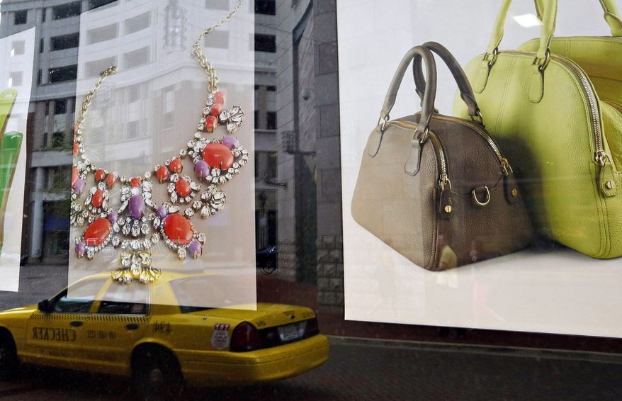 **FILE** Baltimore's Harbor East shopping district is reflected in a retail store's window display on April 24, 2013. (Associated Press)