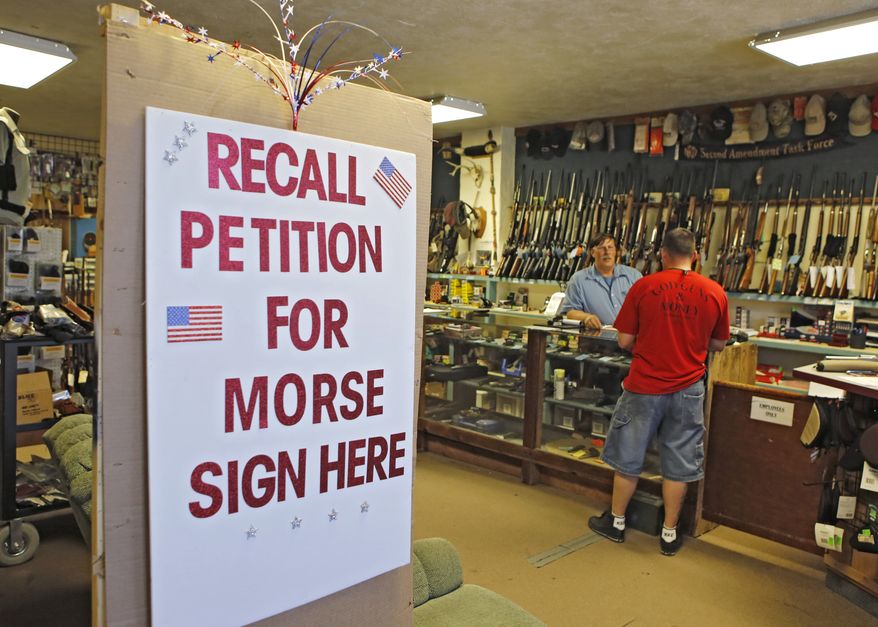 **FILE** A large sign posted at the entrance of Paradise Firearms in Colorado Springs, Colo., invites customers to sign a recall petition against Colorado Democratic State Senate President John Morse on May 24, 2013. In gun-friendly Colorado, gun-rights activists with support of the National Rifle Association are seeking Morse's ouster for his support of new laws that restrict ammunition magazines and expand background checks to private gun sales. (Associated Press)