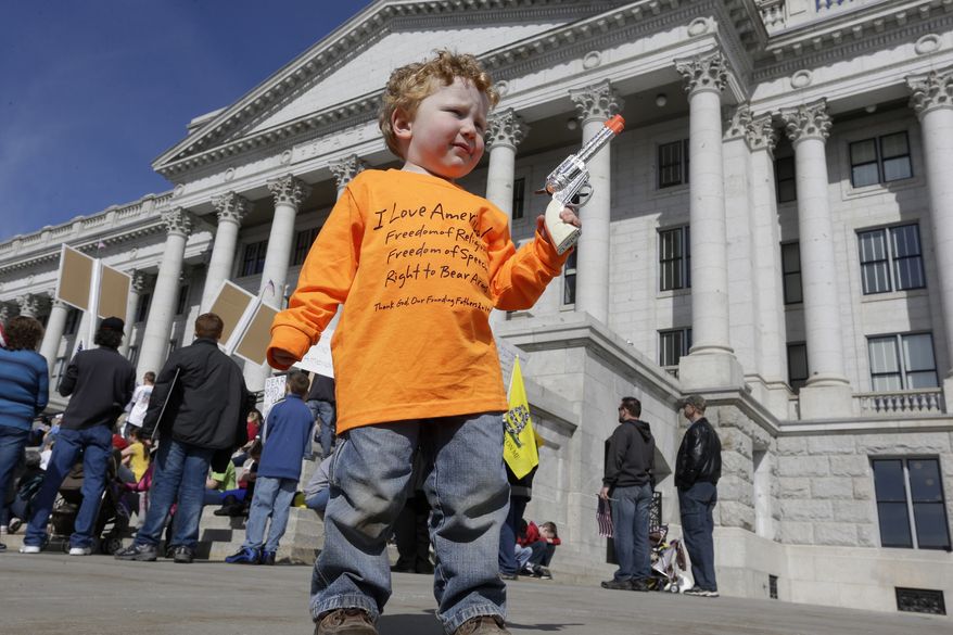 **FILE** Keaton Davidson, 2, holds his toy six-shooter gun during a rally for the 2nd Amendment at the capitol in Salt Lake City on March 2, 2013. (Associated Press)