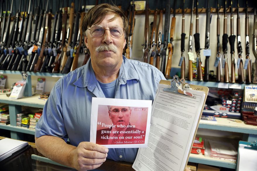 **FILE** Paradise Firearms owner Paul Paradis holds a flyer depicting Colorado's State Senate President, Democrat John Morse, together with a petition to recall him at his gun shop in Colorado Springs, Colo., on May 24, 2013. Paradis and other gun-rights activists are seeking the ouster of Morse for his support of new laws that restrict ammunition magazines and expand background checks to include private gun sales. (Associated Press)