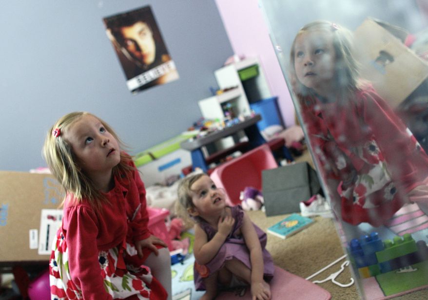 ** FILE ** With her face reflected in a mirror, Coy Mathis, left, a transgender girl, plays with her sister, Auri, 2, center, at their home in Fountain, Colo., on Monday, Feb. 25, 2013. (AP Photo/Brennan Linsley)