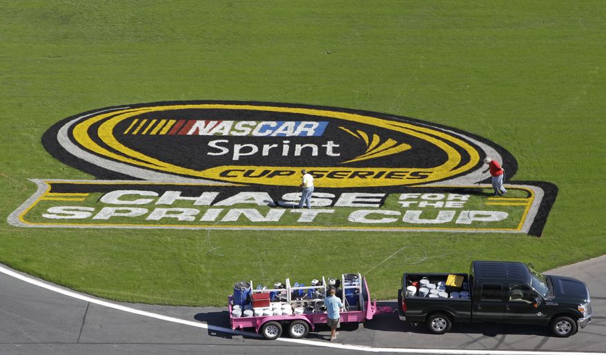 **FILE** Workers paint a logo on the grass near the front stretch during preparation for Saturday's NASCAR Sprint Cup Series auto race in Concord, N.C., Wednesday, Oct. 10, 2012. (AP Photo/Chuck Burton)