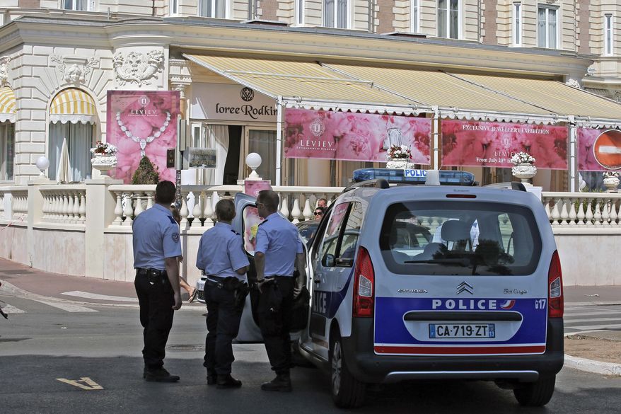 Police stand outside the Carlton Intercontinental Hotel on Sunday, July 28, 2013, in Cannes, France, the scene of the daylight robbery of a staggering $53 million worth of jewels and diamonds in one of Europe's biggest jewelry heists recent years, police said. The French Riviera hotel was hosting a temporary jewelry exhibit over the summer from the prestigious Leviev diamond house, which is owned by Israeli billionaire Lev Leviev. (AP Photo/Lionel Cironneau)